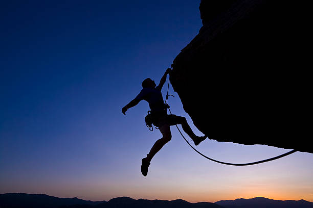 istock Silhouette of rock climber dangling from cliff at night 146741808