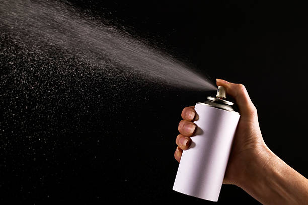 istock Hand depressing silver spray bottle with black background 146741911