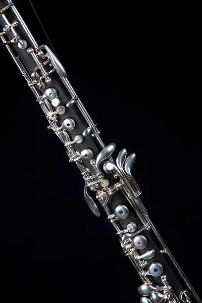 An oboe up close isolated against a black background in the vertical format with copy space.