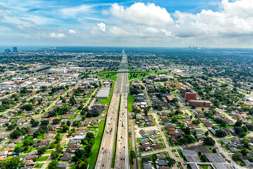 Aerial view of Interstate 10 bisecting Metairie Louisiana from an altitude of about 600 feet with the skyline of New Orleans in the distance.