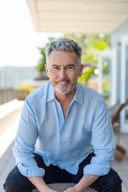 istock Mature man sitting on the balcony looking at the camera. 1467420884