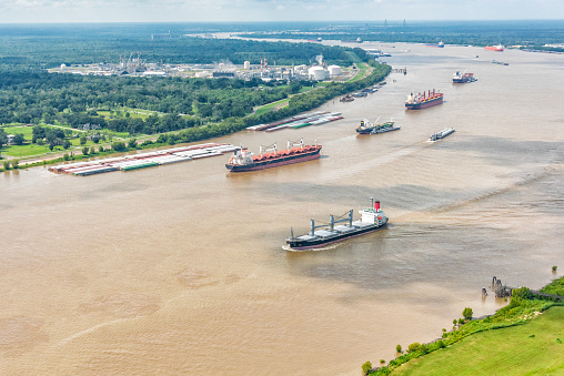 A variety of different cargo ships sailing along the Mississippi River near New Orleans shot from an altitude of about 500 feet.