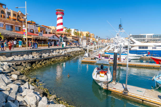 le port de croisière coloré et animé avec des boutiques, des cafés et des bateaux dans la marina le long de la riviera mexicaine à cabo san lucas, au mexique. - marina mexico lighthouse pier photos et images de collection