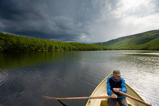 Senior fisherman in a boat at Danube-Tisa-Danube channel near Novi Sad, Serbia.
