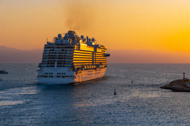 vista nocturna del atardecer de un gran crucero al salir del puerto de cruceros de puerto vallarta, méxico. - passenger ship sunset summer sun fotografías e imágenes de stock