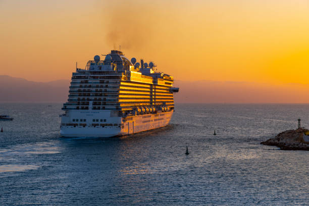 sunset evening view of a large cruise ship as it exits the cruise port of puerto vallarta, mexico. - passenger ship sunset summer sun imagens e fotografias de stock