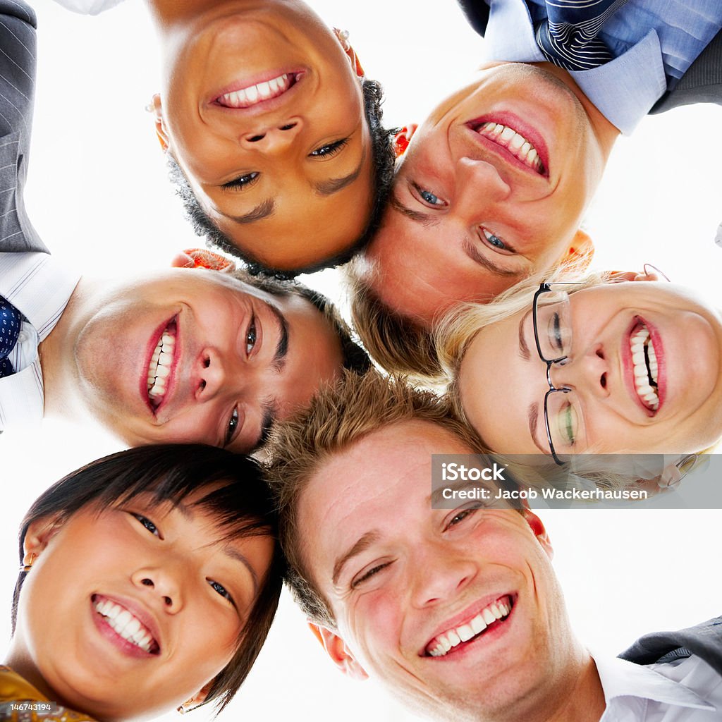 Vista de ángulo bajo de colegas de negocios sonriendo juntos - Foto de stock de Cara humana libre de derechos
