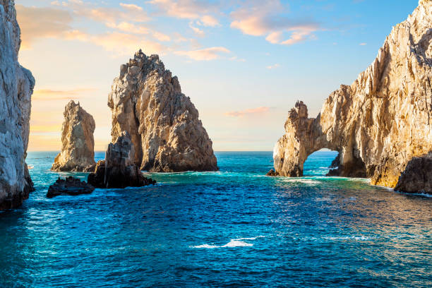 Early sunset view of the El Arco Arch at the Land's End rock formations on the Baja Peninsula, at Cabo San Lucas, Mexico. Early sunset view of the El Arco Arch at the Land's End rock formations on the Baja Peninsula, at Cabo San Lucas, Mexico. The arch of Cabo San Lucas is a distinctive granitic rock formation at the southern tip of Cabo San Lucas, which is itself the extreme southern end of Mexico's Baja California Peninsula. The arch is locally known as "El Arco," which means "the arch" in Spanish, or "Land's End." natural arch stock pictures, royalty-free photos & images