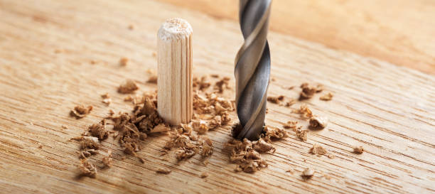 istock drill bit makes hole in wooden oak board for wooden dowel. 1467434644