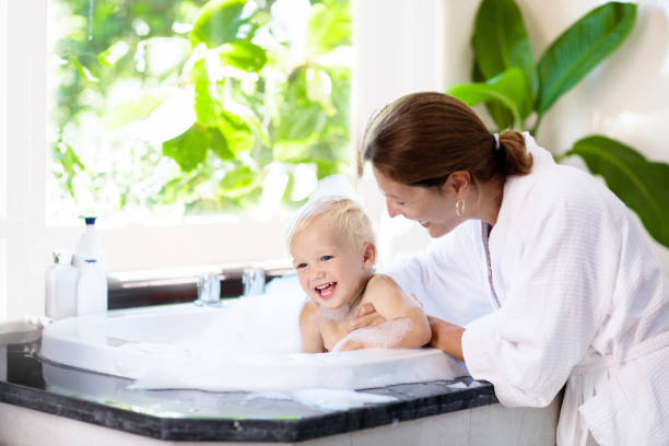 istock Mother washing baby in bubble bath. Water fun. 1467436688