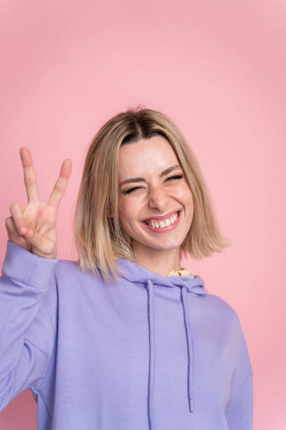 istock Smiling woman showing victory sign 1467440280