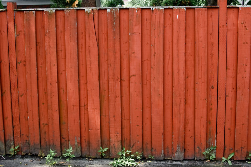 Old red fence located in an urban alley