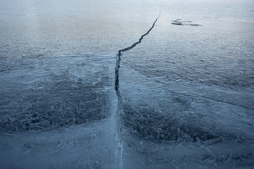 Aerial view over frozen ice blocks in a mountain lake.