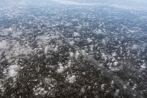 Aerial view over frozen ice blocks in a mountain lake.