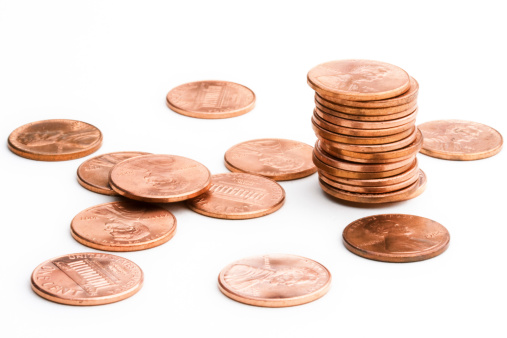 A tower and a heap of Euro coins from 10 cent through 2 Euro on a white background.