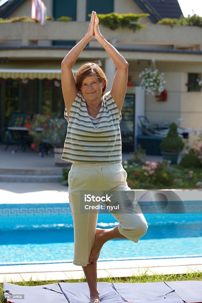 Senior mujer haciendo yoga - Foto de stock de 60-64 años libre de derechos