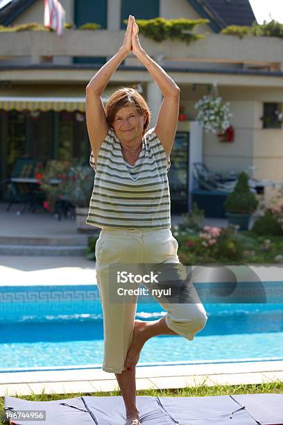 Senior Mujer Haciendo Yoga Foto de stock y más banco de imágenes de 60-64 años - 60-64 años, 60-69 años, 65-69 años