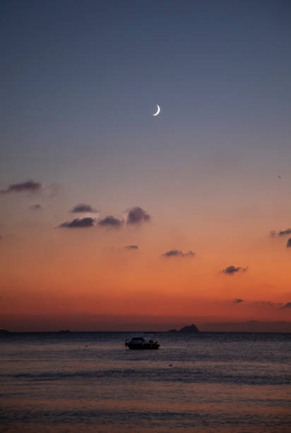 Crescent and clouds at sunset over the sea