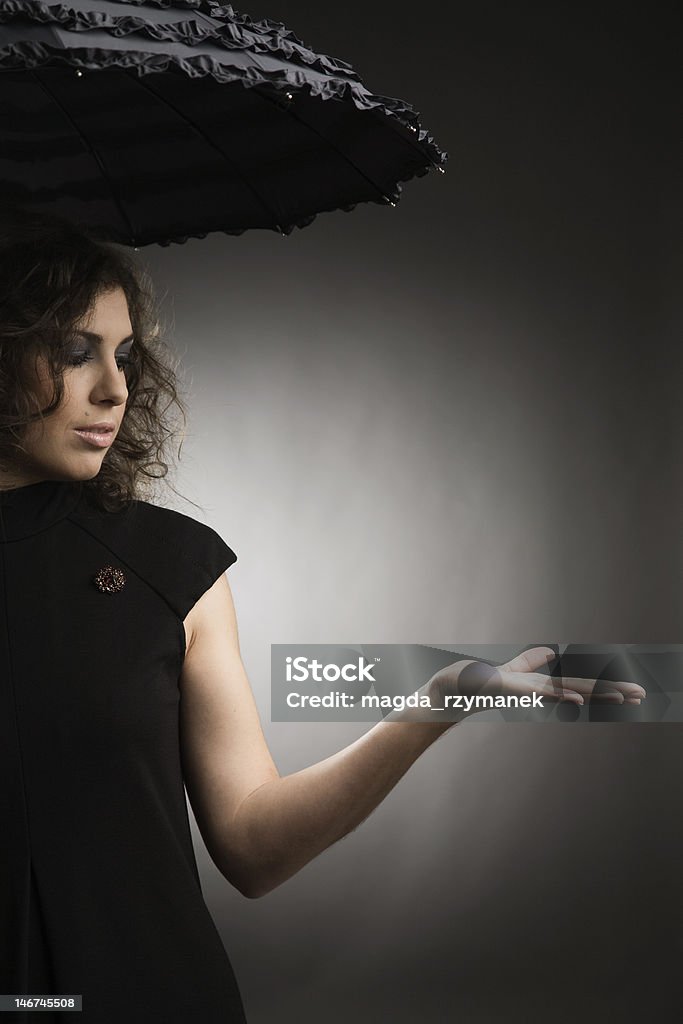 fashion portrait of a young woman in black fashion portrait of a young woman with curly hair in black in studio (canon 5d) Adult Stock Photo