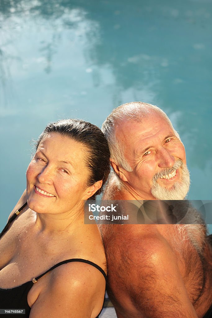 Happily retired couple Older, healthy couple sitting by the water and smiling Mature Couple Stock Photo