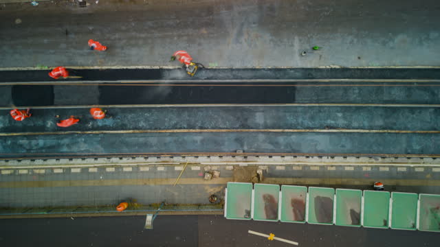 High angle view of asphalting surface between rails on metropolitan rail track. Using machinery at work. Hyper lapse shot. Berlin, Germany