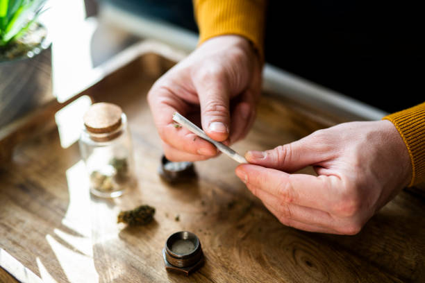 Close-up of a man's hands preparing a joint of marijuana. Close-up of a unrecognizable man's hands preparing a joint of marijuana.  cannabis  stock pictures, royalty-free photos & images