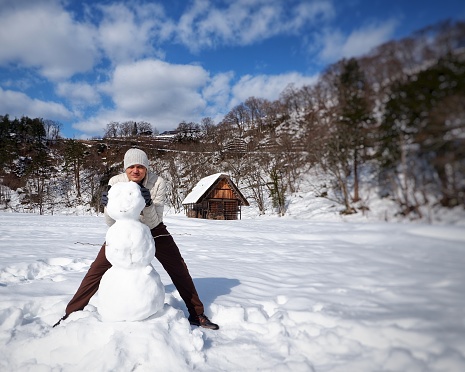 Asian man making Snowman in winter time at Shirakawa-Go