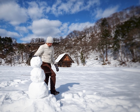 Asian man making Snowman in winter time at Shirakawa-Go