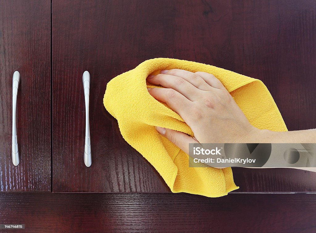 polishing kitchen closet woman's hand polishing the door of mahogany kitchen closet Adult Stock Photo