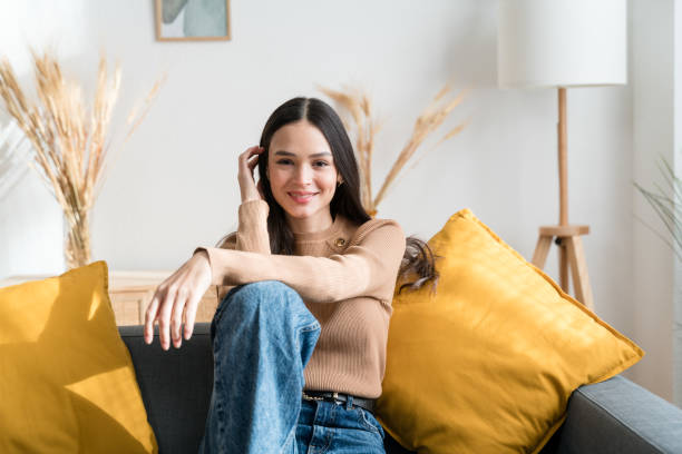 istock Smiling woman sitting on sofa looking at camera 1467468831