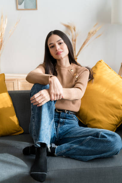 istock Smiling woman sitting on sofa looking at camera 1467468987