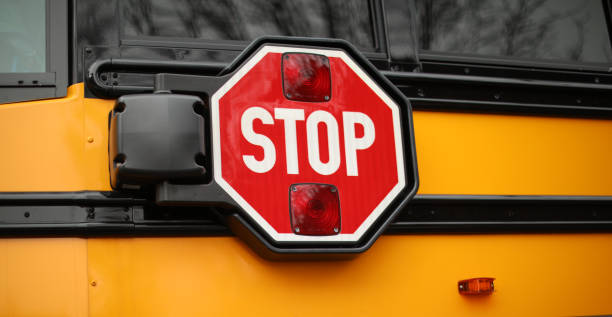 istock yellow school bus in public with stop sign showing 1467472955