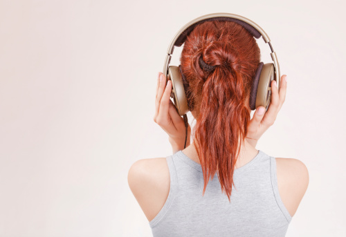 Girl with red hair wearing big headphones