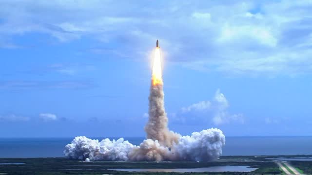 Space shuttle lifting off over water. Shuttle lifts off from the launch pad.