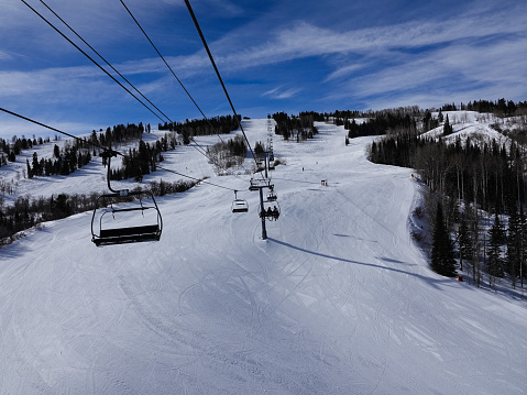 skiers and snowboarders on a wide groomed run. Snowmass ski resort, Aspen, Colorado.