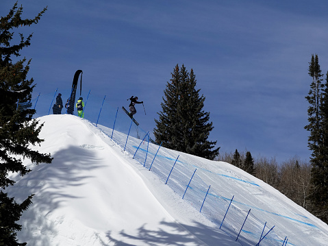 Aspen, Colorado, USA- February 11, 2023: Skier getting big air on a jump at Buttermilk ski resort, Aspen, Colorado.