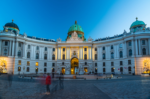 Vienna, Austria - August 30, 2013; Hofburg Palace. Was home for the most powerful people in European and Austrian  Habsburg dynasty Neue Burg section on the photo with eqestrian statue of Emperor Joseph II. Evening view with illuminated building.