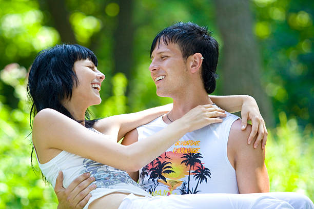 young couple having fun in park stock photo