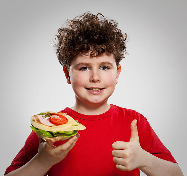 istock Boy eating sandwich showing OK sign 146751030