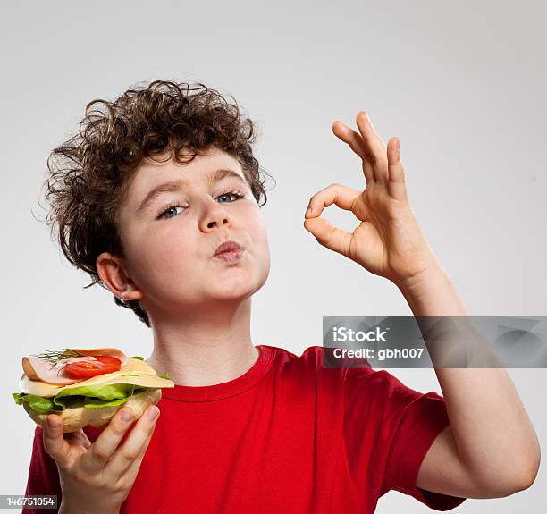 Niño Comiendo Un Sándwich Mostrando Gesto De Ok Foto de stock y más banco de imágenes de Comer - Comer, Niño, Niños