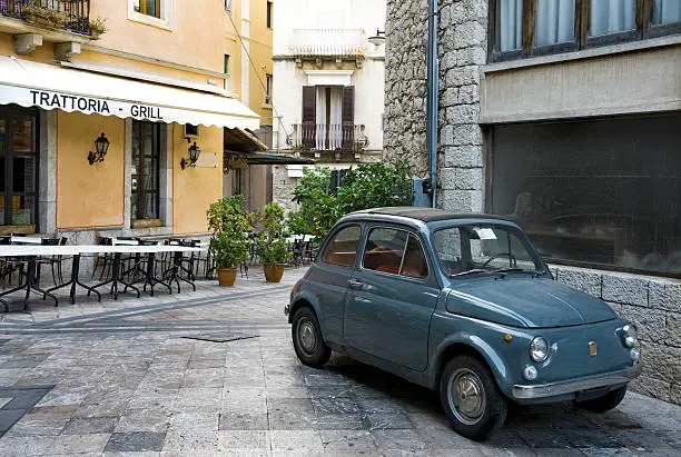 Classic italian car in piazza outside restaurant