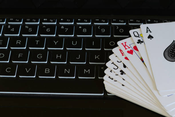 carte tenute sulla tastiera che mostrano giochi online e giochi d'azzardo. ramino online, poker, casinò, black jack, denaro, frode, dipendenza, pubblicità, perdita, profitto, vincita, perdi, club. - rummy foto e immagini stock