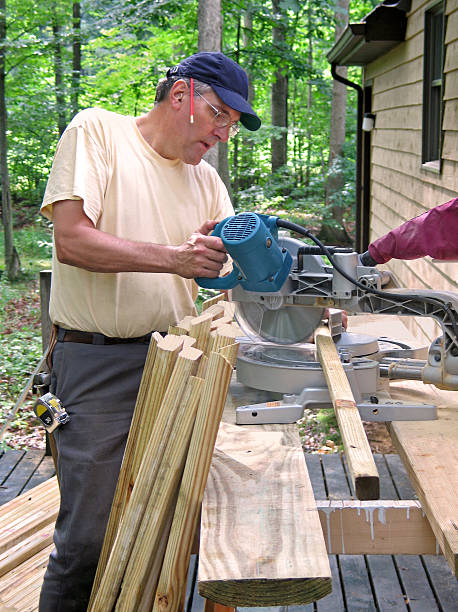 Carpenter using chop saw stock photo