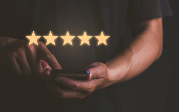 istock Customer service experience and business satisfaction survey with close up man's hand using smart phone and give five star symbol to increase rating of product and service concept. 1467537557