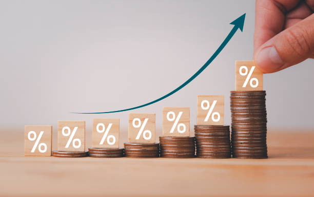 Business investment growth from dividend concept with Increasing stacking of money coins with white arrow up and percentage sign for increase financial interest rate. Copy space. crecimiento de la inversión empresarial desde el concepto de dividendos con el aumento del apilamiento de monedas de dinero con flecha blanca hacia arriba y signo de porcentaje para aumentar la tasa de interés financiera. espacio de copia.