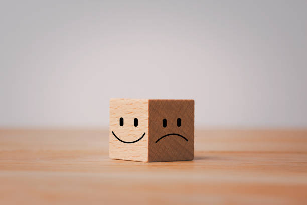 istock Smile face in bright side and sad face in dark side on wooden block cube for positive mindset selection. Mental health and emotional state concept 1467537741