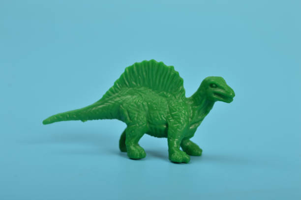 istock Toy spinosaurus dinosaurs isolated on a blue background 1467539277