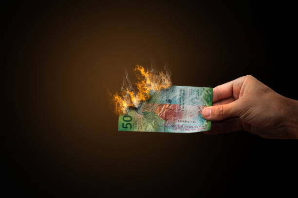 istock Swiss Franc burning flame held by hand 1467541418