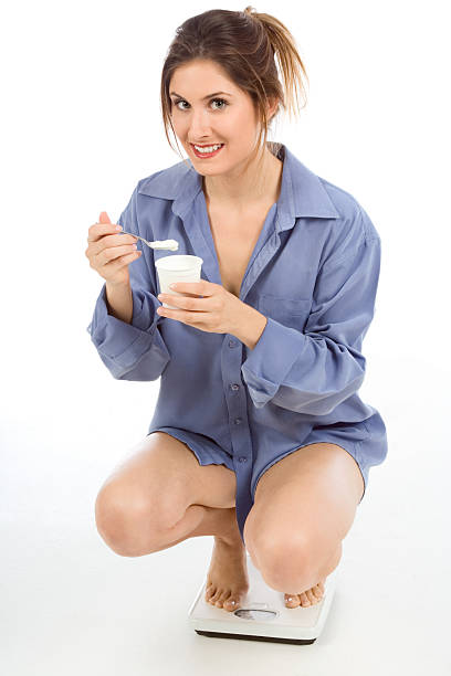 mujer en balanzas de comer saludable yogur - women spoon tasting elegance fotografías e imágenes de stock