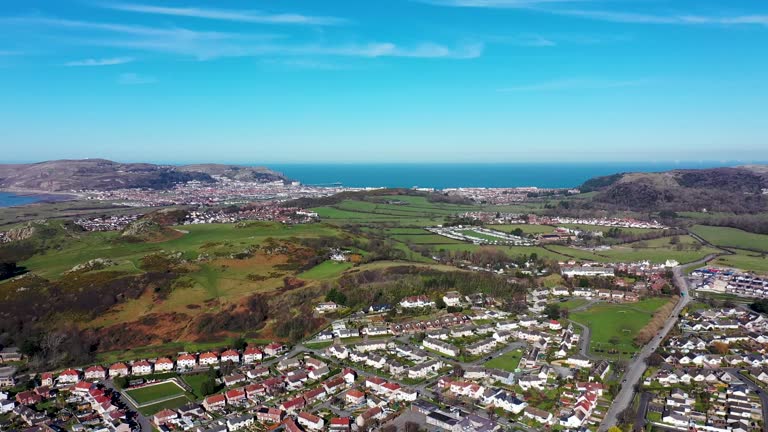 Aerial footage of the town of Deganwy in Conwy County Borough in Wales It lies in the Creuddyn Peninsula alongside Llandudno Rhos-on-Sea showing residential housing estates in the town.